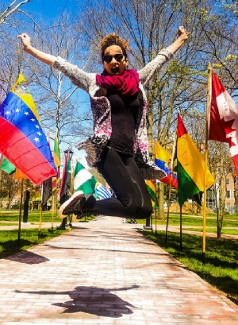 国际活动周参与者在一排国际旗帜前跳跃.